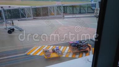带有行李的行李牵引车通过机场空中桥附近的一个人行横道。